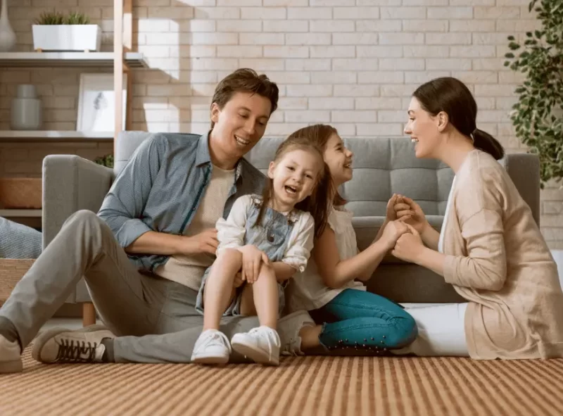 Happy Family sitting in the carpet